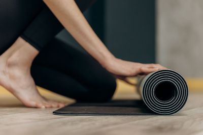 Woman on yoga mat home postnatal routine