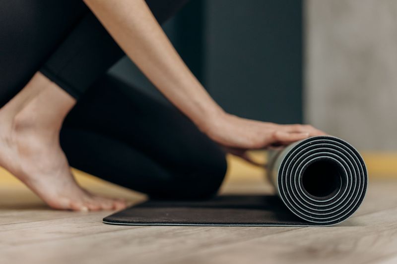 Woman on yoga mat home postnatal routine
