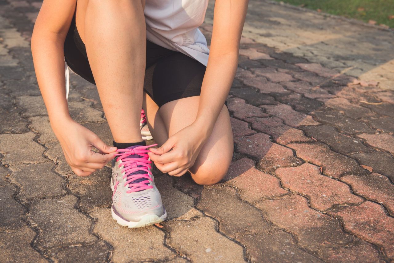 woman lacing running shoes morning