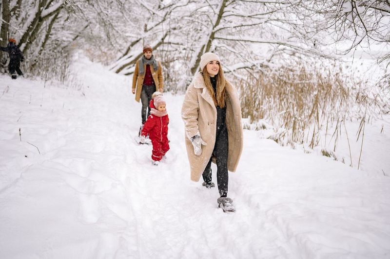family walking snow winter
